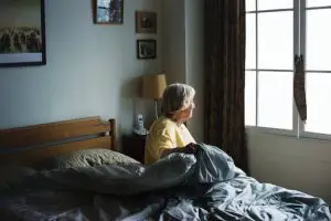Older woman sitting on a bed